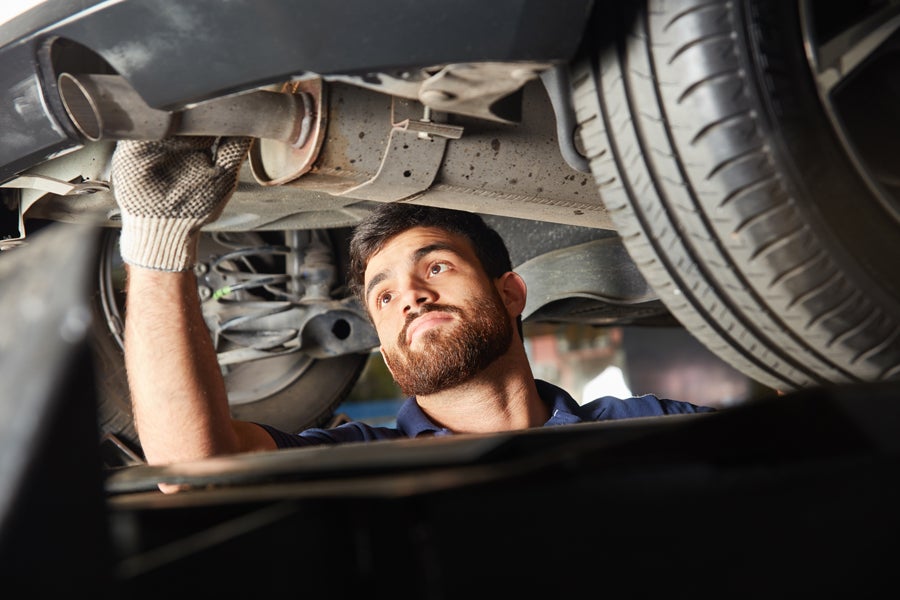 Service tech working underneath a vehicle