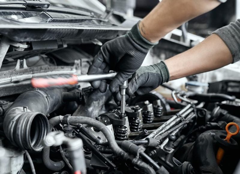 a person using a wrench on a vehicle