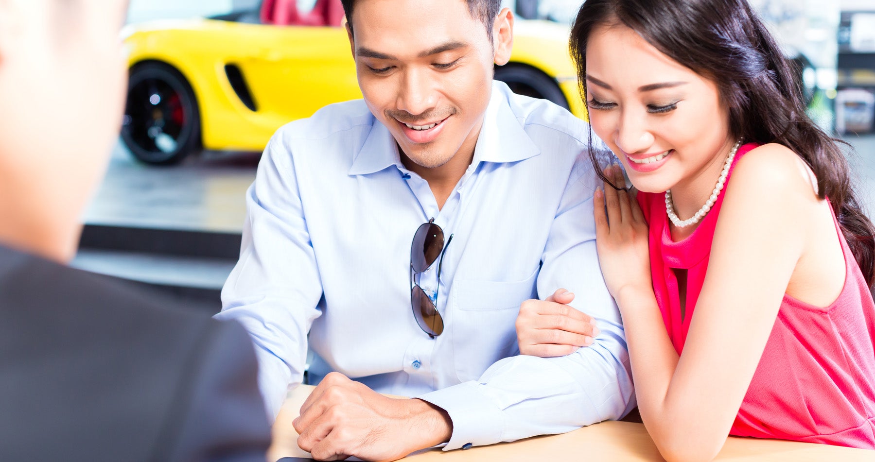 A man and woman going over paperwork with dealer